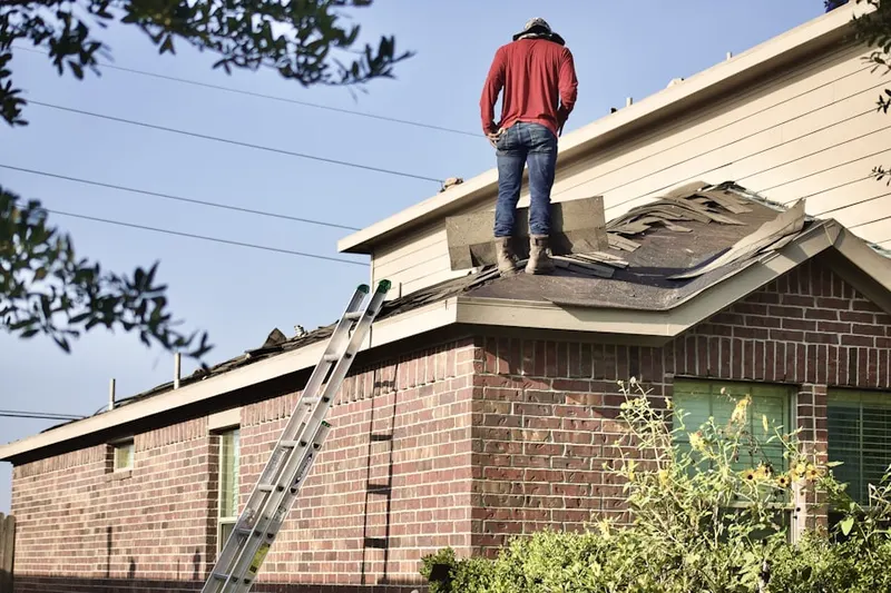 Professional roofer working on a residential roof in Colony Club